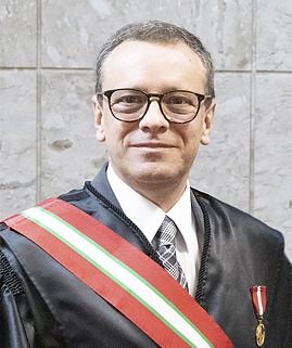 Foto de um homem branco vestido de beca e uma medalha no peito