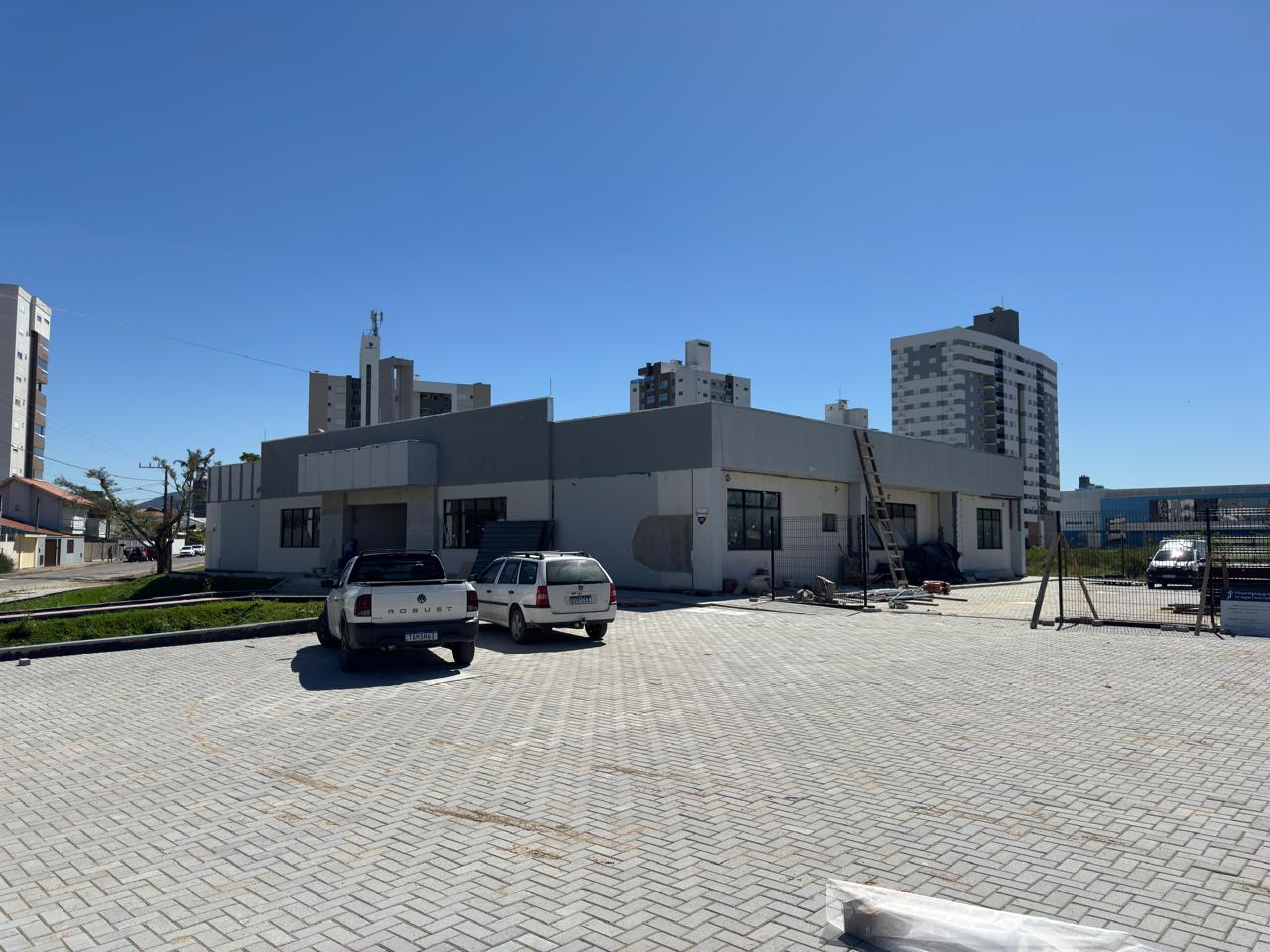 Foto - vista geral da obra, estacionamento com paver de concreto e prédio ao fundo