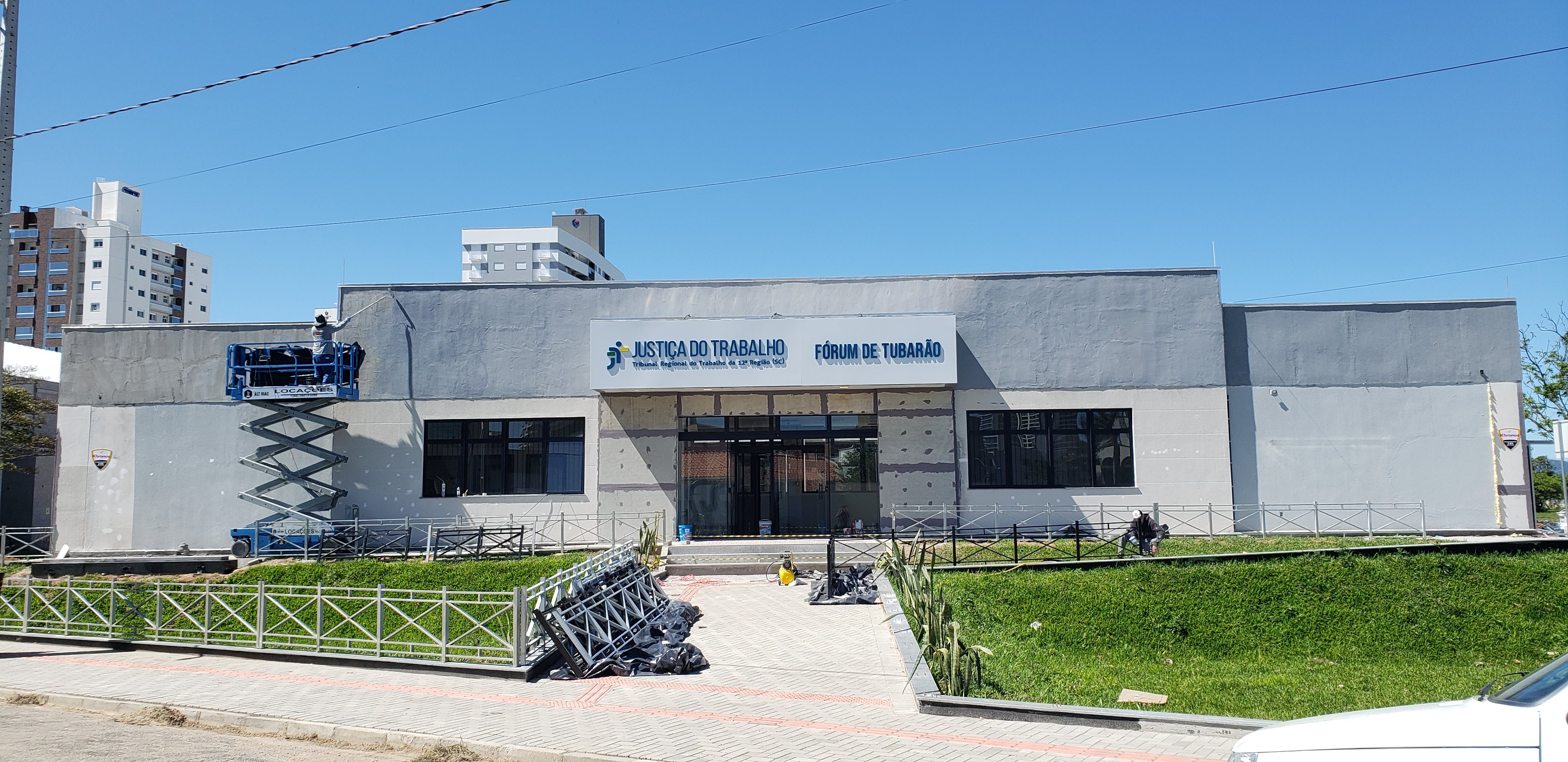 Foto - fachada principal em fase de pintura e acabamentos, identificação do prédio já instalada (letreiro)