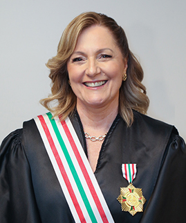 Foto de uma mulher branca vestida de beca e uma medalha no peito