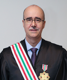 Foto de um homem branco vestido de beca e uma medalha no peito