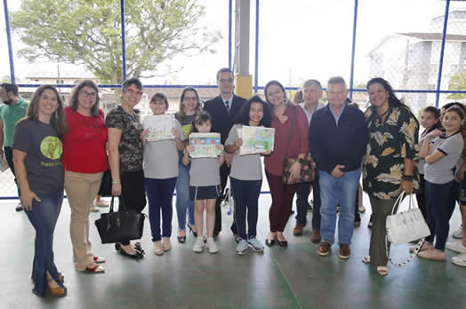 Na foto, prefeito Udo Döhler (à dir), crianças e seus familiares durante cerimônia de premiação