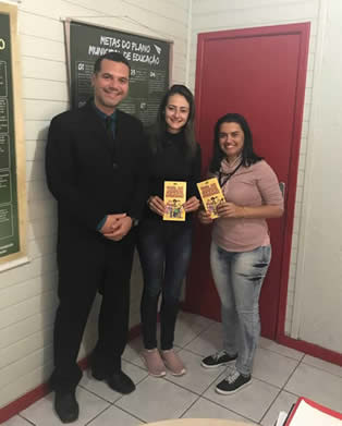 Na foto, juiz Sílvio Schneider, secretária de educação adjunta, Liliane Debacker e coordenadora de ensino, Rafaela Roque segurando o Guia do Jovem Aprendiz