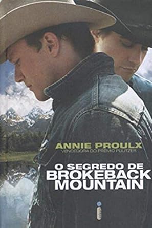 Para todos verem: Banner com dois homens usando chapéu de cowboy com um rio e uma montanha ao fundo. No banner se lê: "Annie Proulx. Vencedora do Prêmio Pulitzer. O Segredo de Brokeback Mountain. Intrínseca.