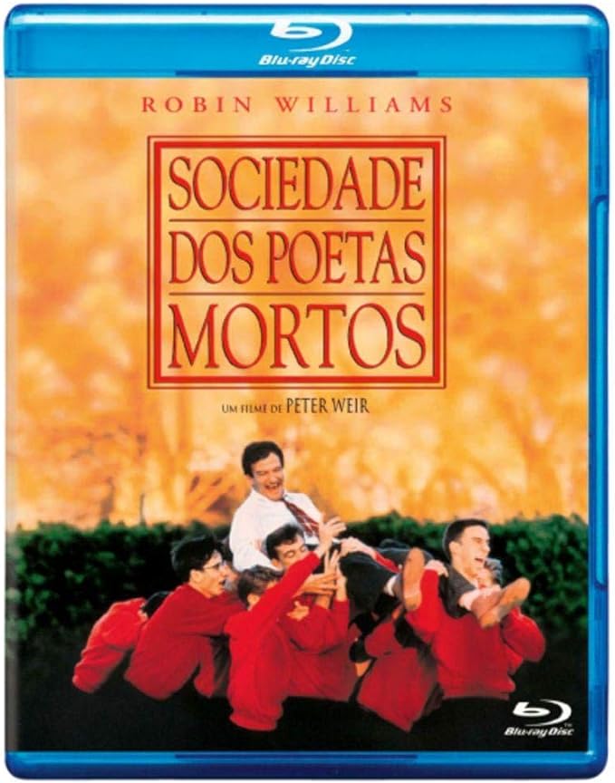 Para todos verem: Banner do filme em que há um homem de camisa social branca e gravata vermelha sendo carregado por vários jovens que usam um suéter vermelho. Lê-se: "Blu-Ray Disc. Robin Williams. Sociedade dos Poetas Mortos. Um filme de Peter Weir. Blu-Ray Disc".