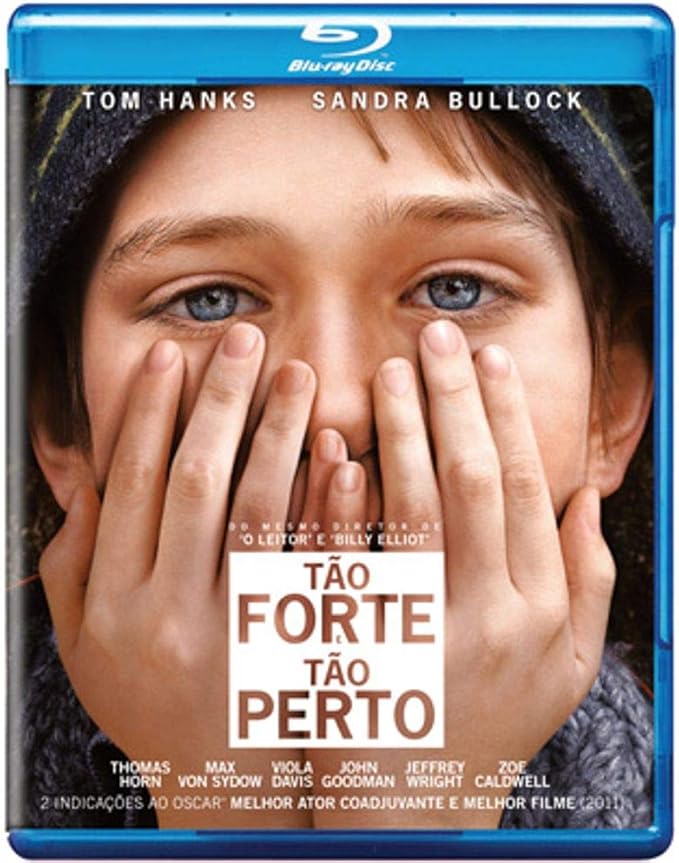 Para todos verem: Texto: "Blu-ray Disc. Tom Hanks. Sandra Bullock. Do mesmo diretor de O Leitor e Billy Elliot. Tão Forte e Tão Perto. Thomas Horn. Max von Sydow. Viola Davis. John Goodman. Jeffrey Wright. Zoe Caldwell. Duas Indicações ao Oscar - Melhor Ator Coadjuvante e Melhor Filme –-2011”. Ilustração: Banner em que um menino tapando parte do rosto com as mãos.