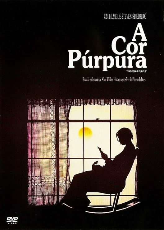 Banner do filme em tons de roxo em que uma mulher está sentada em uma cadeira de balanço ao lado de uma janela com sol. No banner se lê: "Um filme de Steven Spielberg. A Cor Púrpura. The Color Purple".