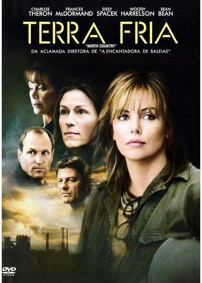 Para todos verem: Banner do filme em que há uma mulher de jaqueta verde. Ao fundo há o rosto de duas mulheres e de dois homens. Lê-se: "Charlize Theron. Frances McDormand. Sissy Spacek. Woody Harrelson. Sean Bean. Terra Fria. North Country. Da aclamada diretora de A encantadora de baleias. DVD Vídeo".