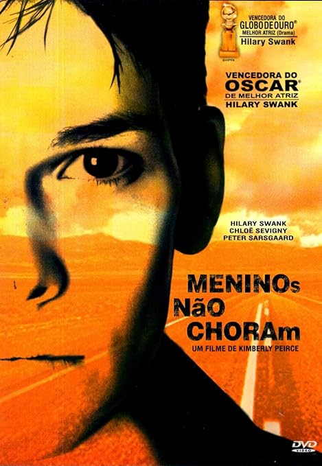 Para todos verem: Banner do filme em tons de amarelo e laranja em que há o rosto de uma pessoa. Ao fundo há montanhas e uma estrada. Lê-se: "Vencedora do Globo de Ouro Melhor Atriz (Drama) Hilary Swank. Vencedora do Oscar de Melhor Atriz Hilary Swank. Hilary Swank. Chloë Sevigny. Peter Sarsgaard. Meninos Não Choram. Um filme de Kimberly Peirce. DVD Vídeo".