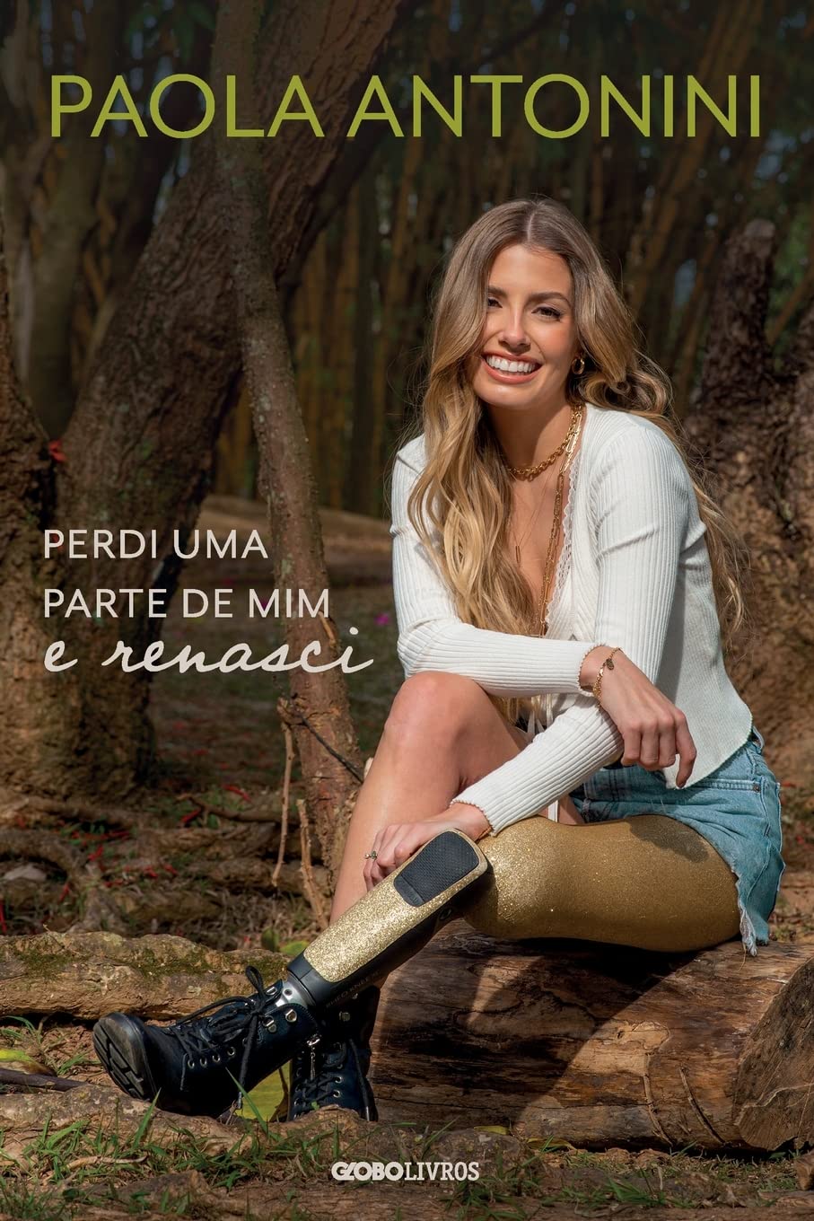 Para todos verem: Texto: “Paola Antonini. Perdi uma parte de mim e renasci. Globo Livros. Ilustração: Capa do livro em que há a foto de uma mulher utilizando uma prótese na perna sentada em uma floresta.