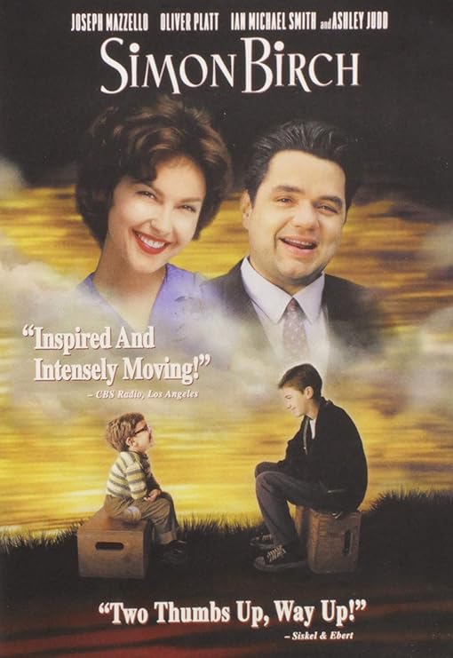 Para todos verem: Texto: "Joseph Mazzello. Oliver Platt. Ian Michael Smith and Ashley Judd. Simon Birch. Inspired And Intensely Moving! - CBS Radio, Los Angeles. Two Thumbs Up, Way Up! - Siskel e Ebert". Ilustração: Banner em que há, na parte superior, um homem e uma mulher. Na parte inferior há duas crianças sentadas em caixas.