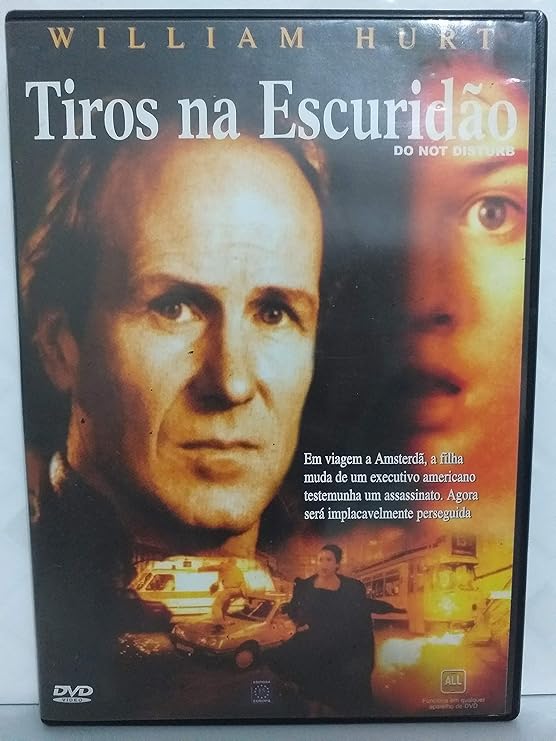 Para todos verem: Texto: "William Hurt. Tiros na Escuridão. Do Not Disturb. Em viagem a Amsterdã, a filha muda de um executivo americano testemunha um assassinato. Agora será implacavelmente perseguida. DVD Video. Editora Europa". Ilustração: Banner em tons de preto, laranja e amarelo em que na parte superior esquerda há um homem. Na parte superior direita há uma jovem com os olhos arregalados e a boa aberta. Na parte inferior há veículos e duas pessoas.