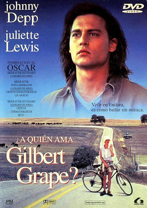 Para todos verem: Texto: "DVD Vídeo. Johnny Depp. Juliette Lewis. Nominacion al Oscar. Mejor Acotr Secundario - Leonardo DiCaprio. Mejor Actor Nueva Generacion - Leonardo DiCaprio - Criticos Cinematograficos Los Angeles. Mejor Actor Nueva Generacion - Leonardo DiCaprio - Criticos Cinematograficos EEUU. A Quien Ama Gilbert Grape? Vivir em Endora, es como bailar sin música. Dolby Digital. www.laurenfilm.es . Lauren Films”. Ilustração: Banner em que na parte superior há um homem. Na parte inferior há uma mulher do lado de uma bicicleta em uma estrada. 