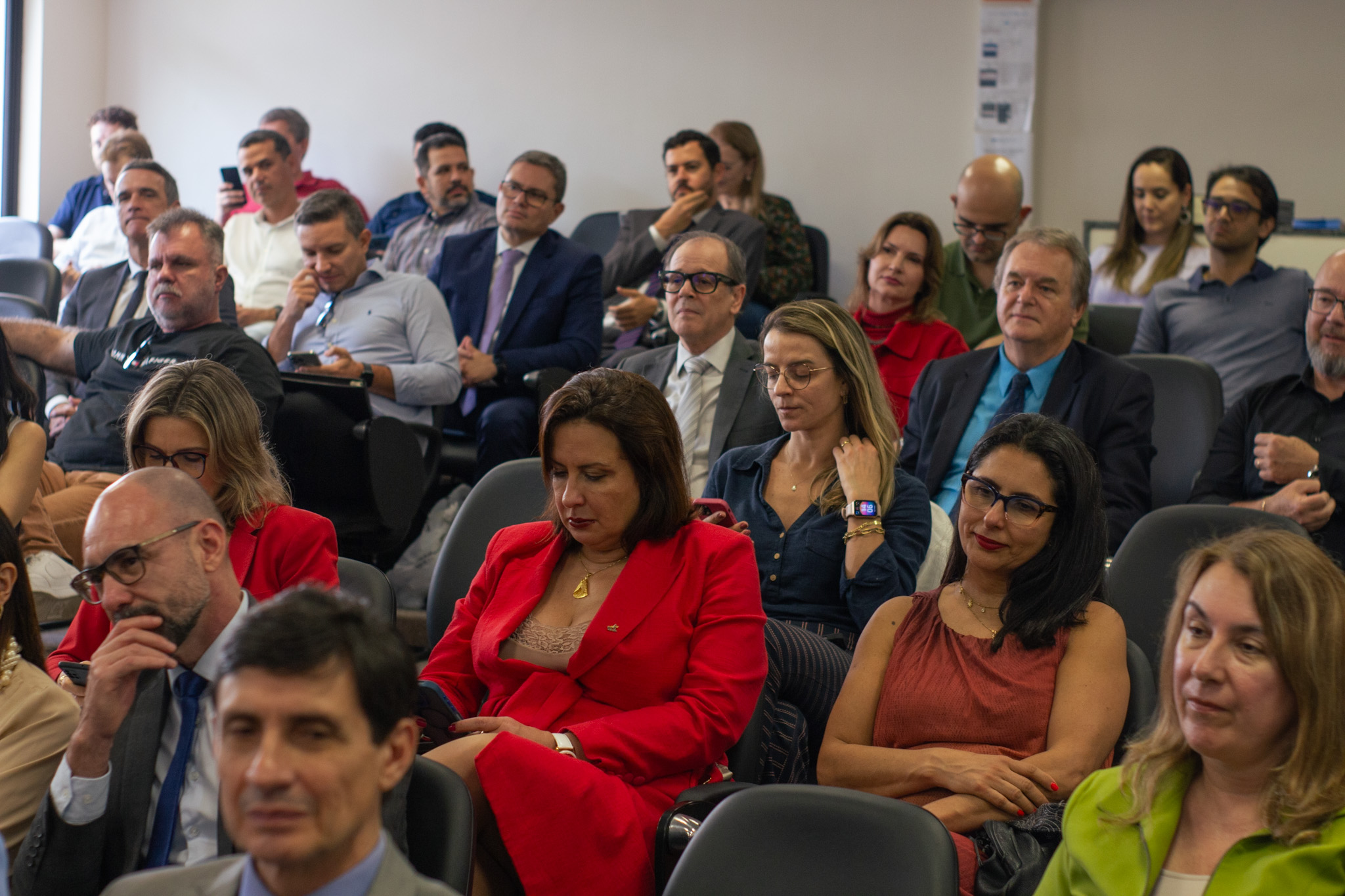 Foto geral de um público sentado em um auditório