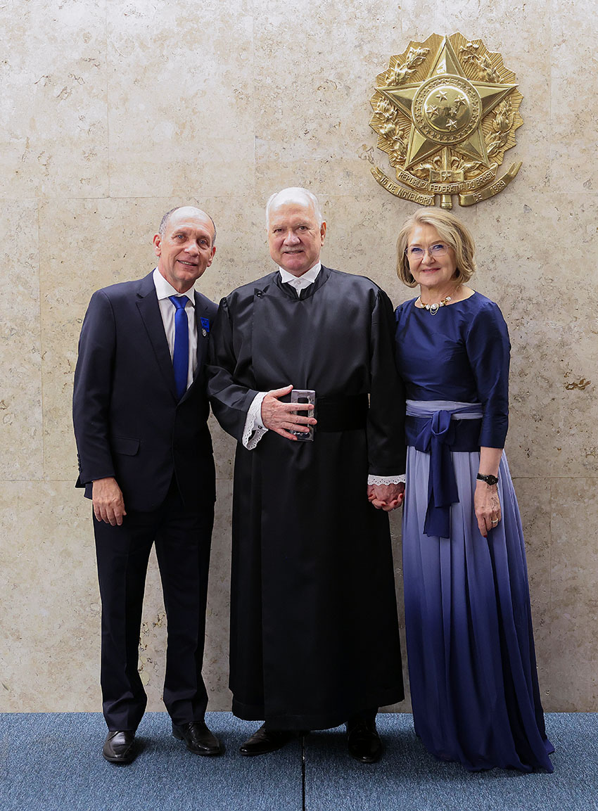 Três pessoas com trajes sociais posam para foto.