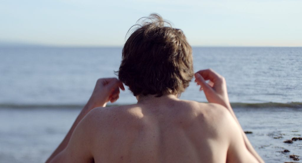 Para todos verem:  Ilustração: Foto com um homem com os braços levemente erguidos de frente para o mar.