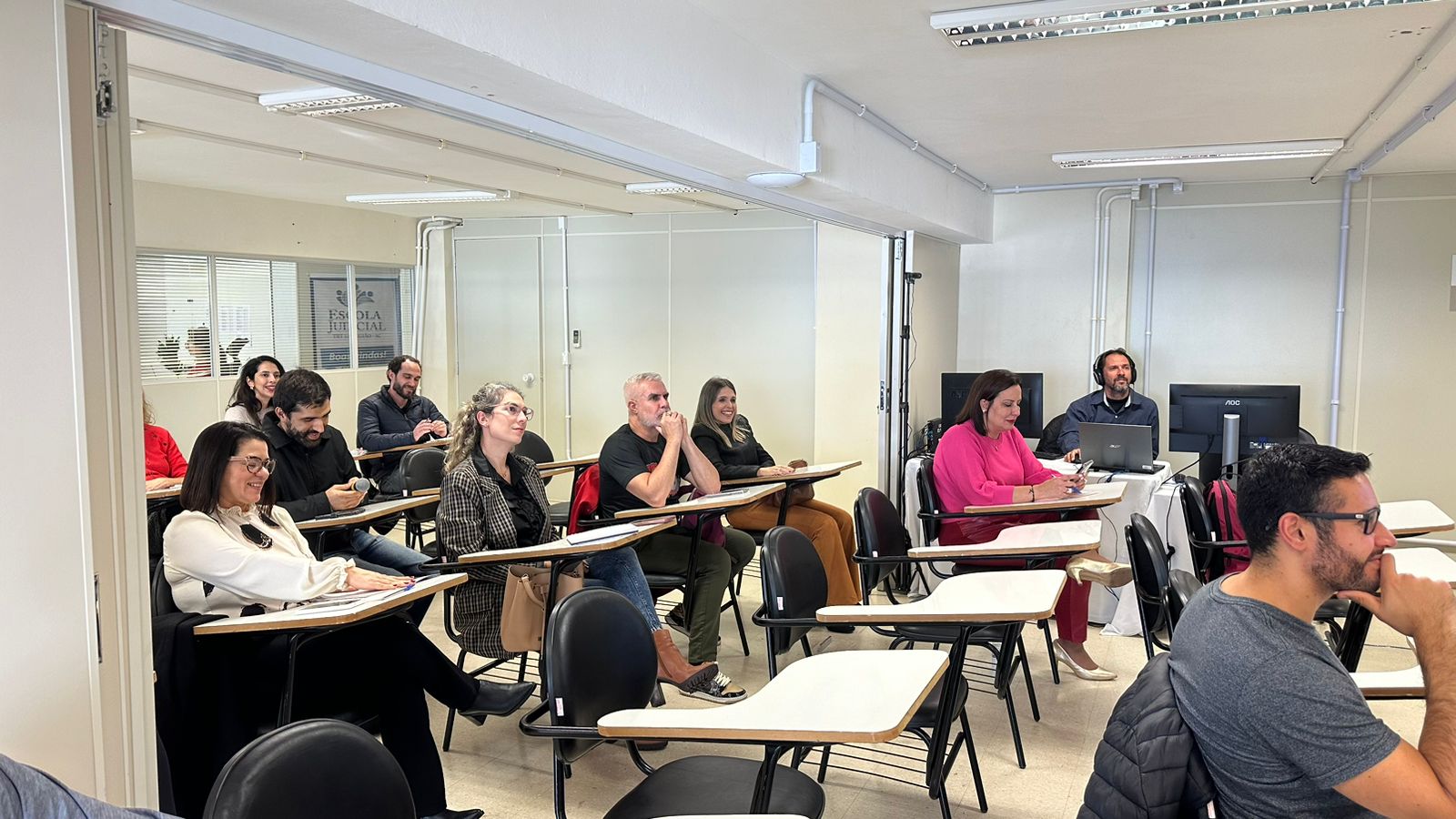 fotografia de pessoas sentadas em cadeiras acompanhando palestra