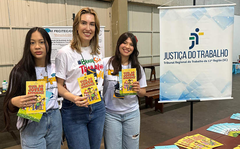 Uma mulher e duas meninas seguram o guia do jovem aprendiz