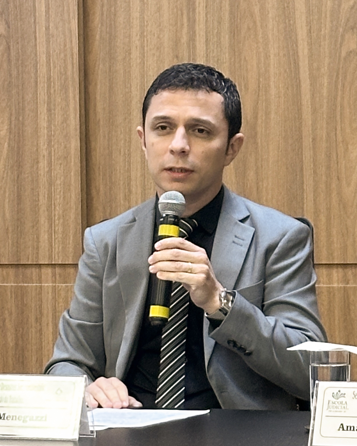 Homem de terno fala ao microfone