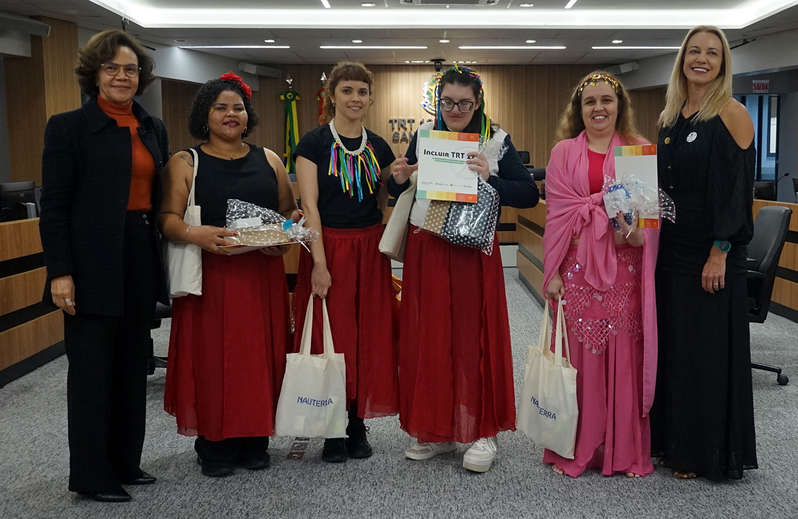 Seis mulheres posando para foto com certificado de participação nas mãos