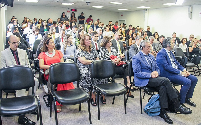 Foto em ângulo aberto mostra público presente no auditório do tribunal durante o colóquio