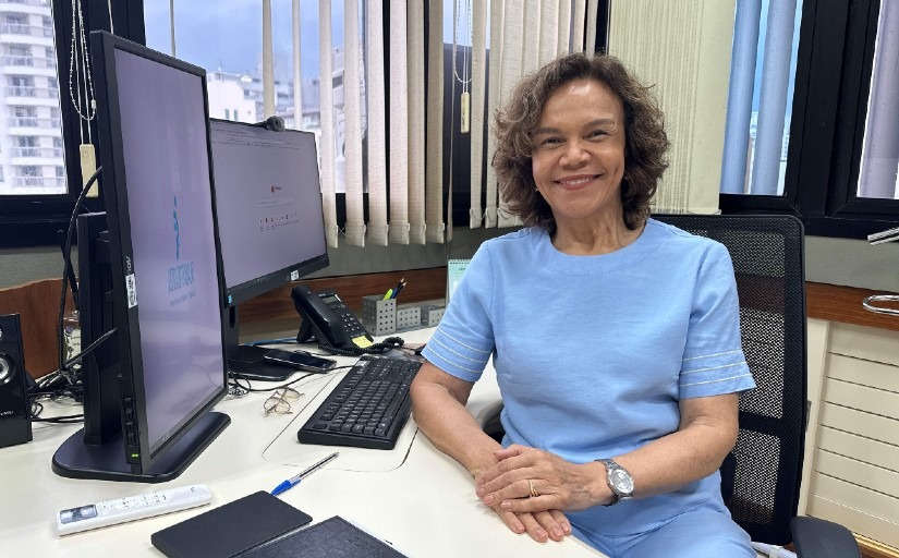 Mulher vestindo traje azul posa sorrindo