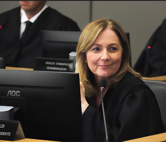 Mulher de cabelos louros ri timidamente