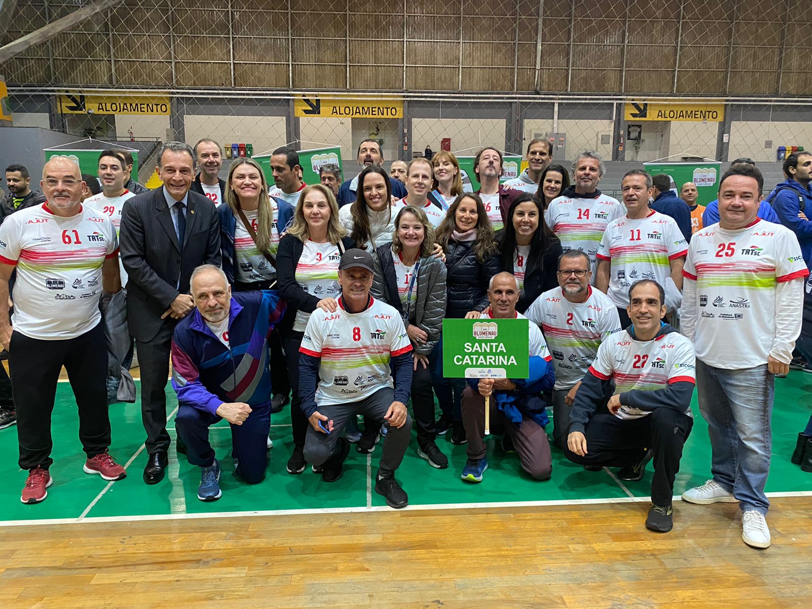 Foto da delegação de Santa Catarina, com o presidente, desembargador José Ernesto Manzi, e o ministro Alexandre Luiz Ramos. Os atletas vestem o uniforme esportivo de Santa Catarina