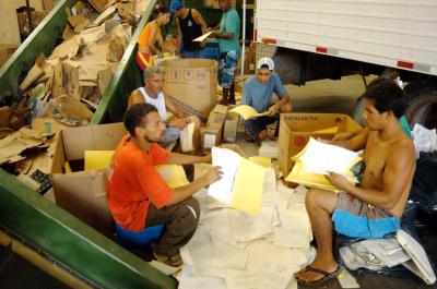 trabalhadores em usina de reciclagem de papel, debulhando autos findos