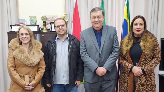 Dois homens e duas mulheres sorridentes posam para a foto