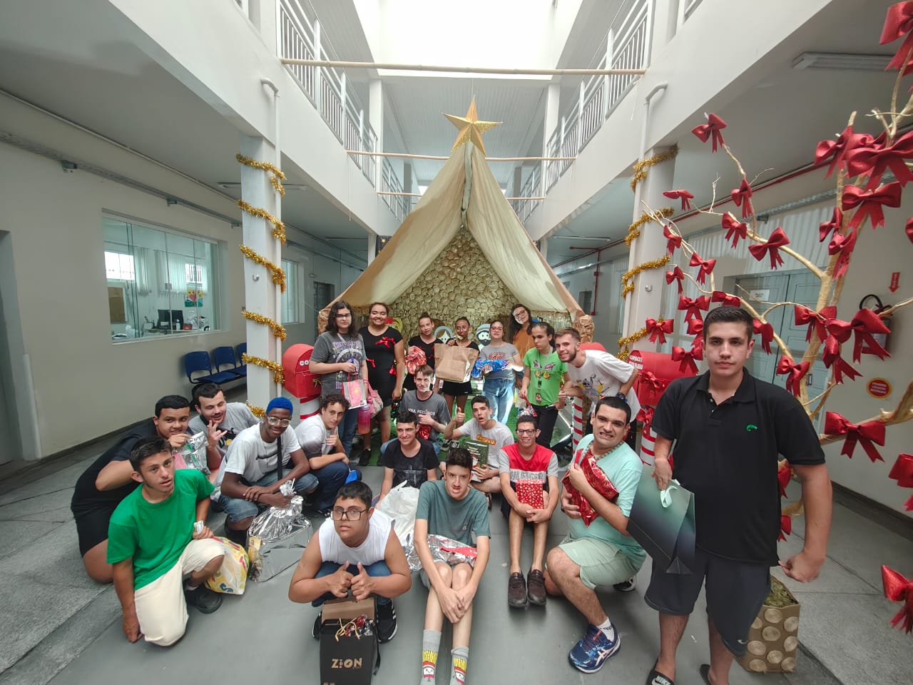 Foto de cerca de 20 jovens exibindo os presentes recebidos