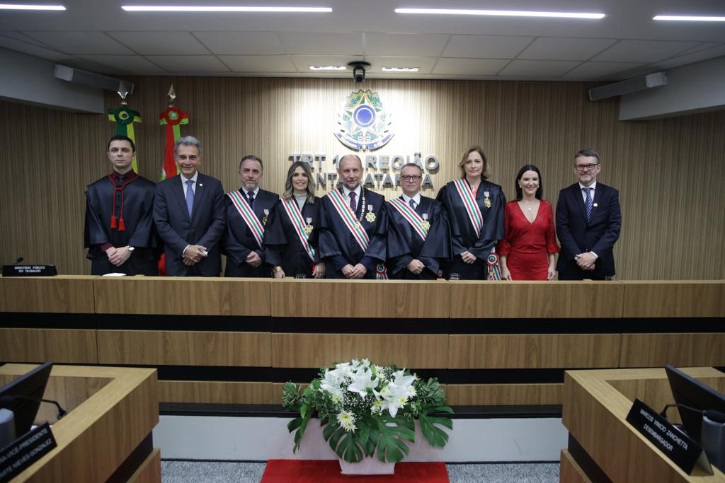 Foto de uma sala de sessão judiciária com várias pessoas sentadas