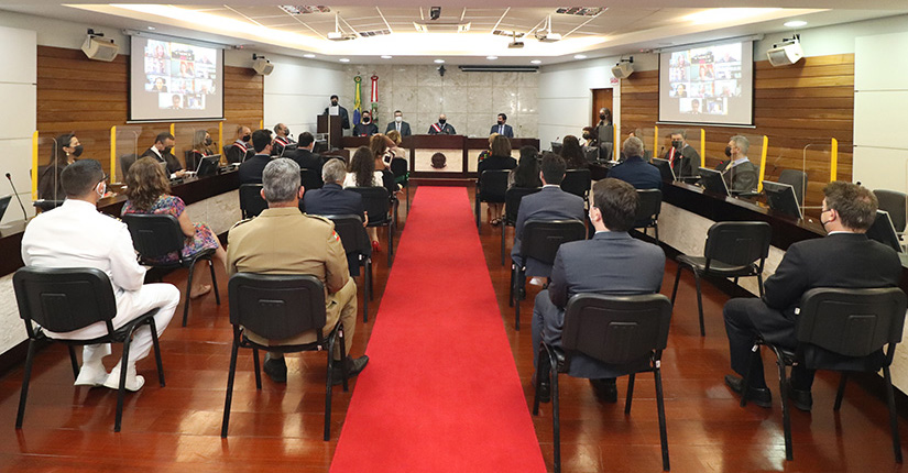 Foto aberta da sala de sessões do Pleno, mostrando a mesa de honra do evento e convidados
