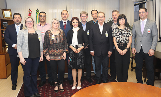 Desembargadora Mari Eleda (c) e juiz Marcel Higuchi com representantes da Unisul e de sindicatos de professores e auxiliares de ensino durante reunião em outubro 