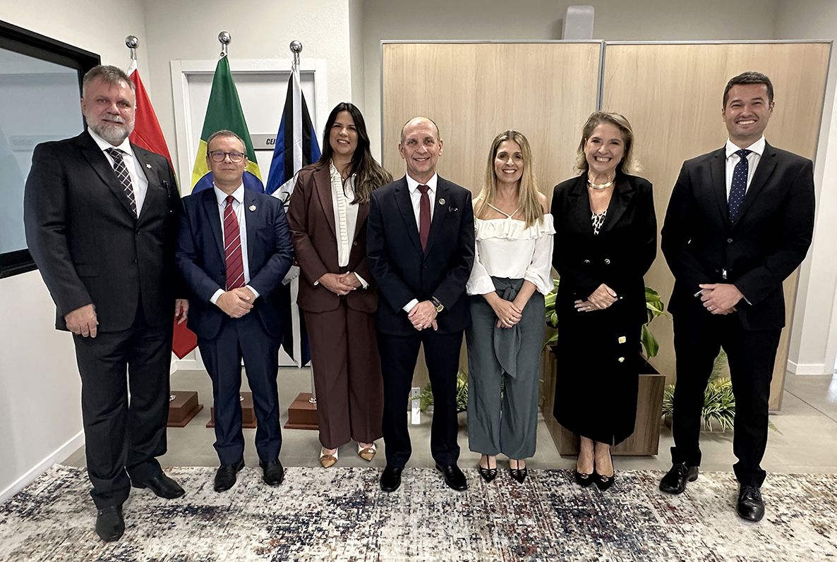 Homens e mulheres vestindo trajes sociais posando para foto