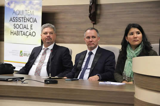 Na foto, juiz Helio Romero e outras duas pessoas sentados à mesa