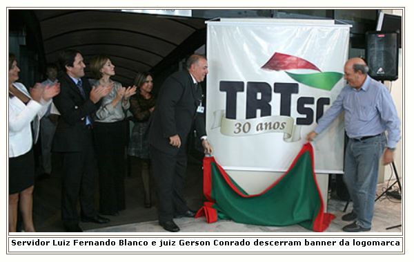 Servidor Luiz Fernando Blanco e juiz Gerson Conrado descerram banner da logomarca de 30 anos do TRT-SC