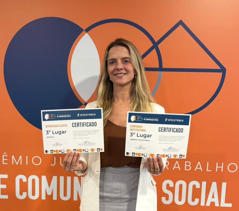 Mulher loira, aparentando ter 30 anos, exibe dois certificados 