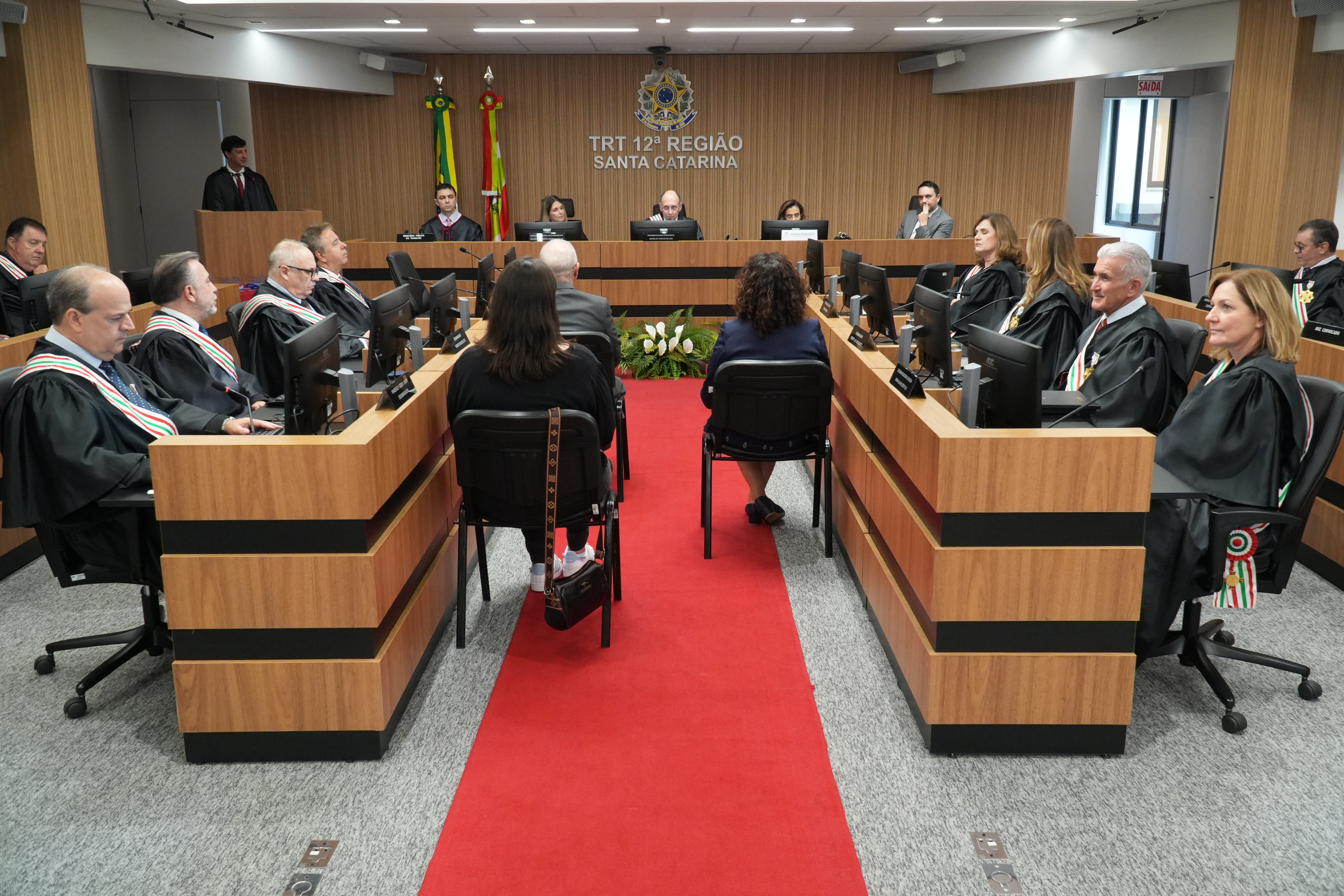 Diversas pessoas sentadas assistindo abertura de sessão em uma plenária