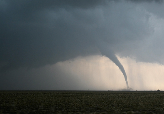 tornado se formando ao fundo de uma área rural