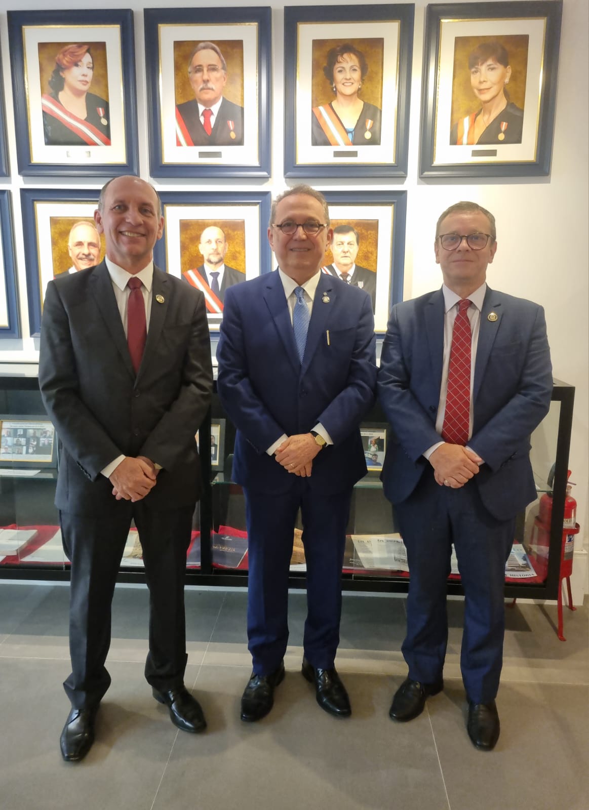 Três homens estão em pé posando para a foto