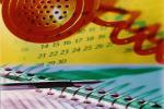 Imagem de parte de um calendário, um telefone e um caderno com um lápis em cima