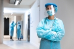 Foto de uma profissional de saúde vestida com equipamentos de proteção individual, em um ambiente hospitalar