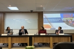 Dois homens e duas mulheres sentados à mesa de um evento