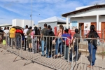 Imagem mostra uma fila de pessoas no que parece ser um posto de imigração