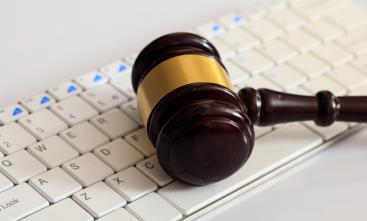 Martelo da Justiça sobre um teclado branco. Texto branco sobre uma faixa amarela: Vara Digital. TRT-SC implanta Núcleo 4.0 para aprimorar acesso à Justiça. 