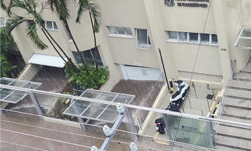 Fotografia aérea de uma rua alagada, com a água invadindo uma garagem.