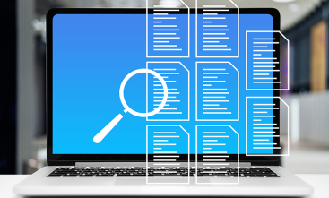 Imagem de um notebook aberto com uma tela azul. Sobre a imagem, ícones de documentos e uma lupa, que sugerem uma ação de busca.