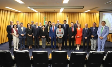 Grupo de pessoas em pé, posando para a foto, em frente a uma bancada