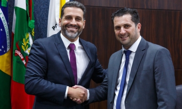 Dois homens de terno dando as mãos em cumprimento